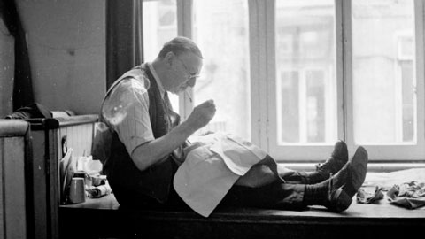 tailor on bench, sewing